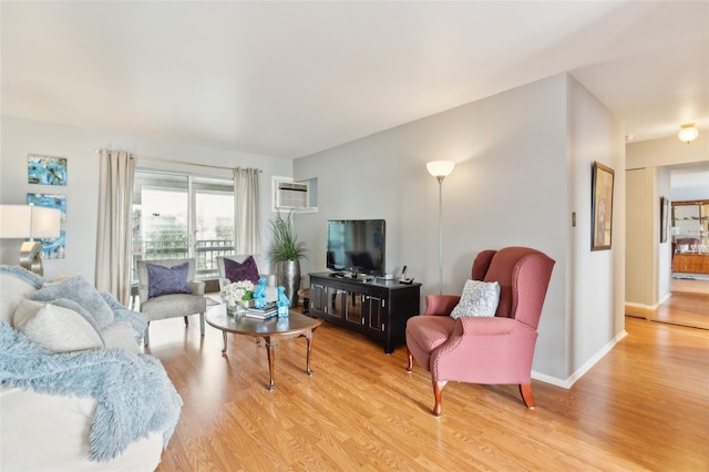 living room featuring light hardwood / wood-style floors and an AC wall unit