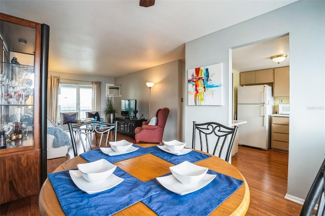 dining room featuring light hardwood / wood-style flooring and a wall mounted AC