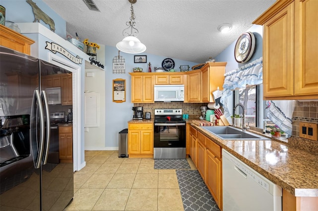 kitchen featuring lofted ceiling, sink, light tile patterned floors, pendant lighting, and stainless steel appliances