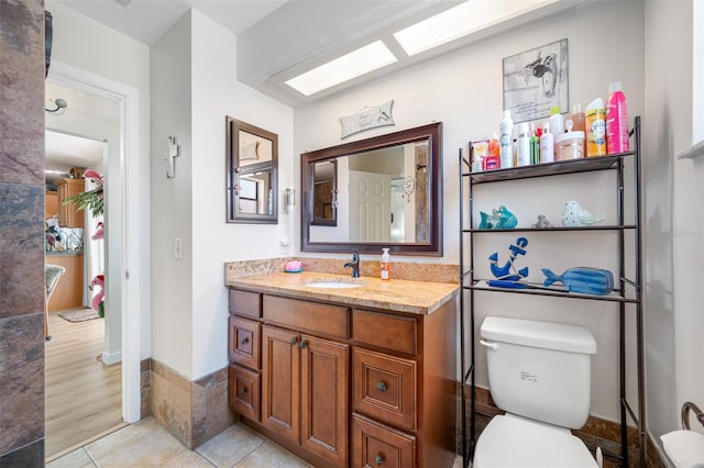 bathroom featuring vanity, tile patterned floors, and toilet