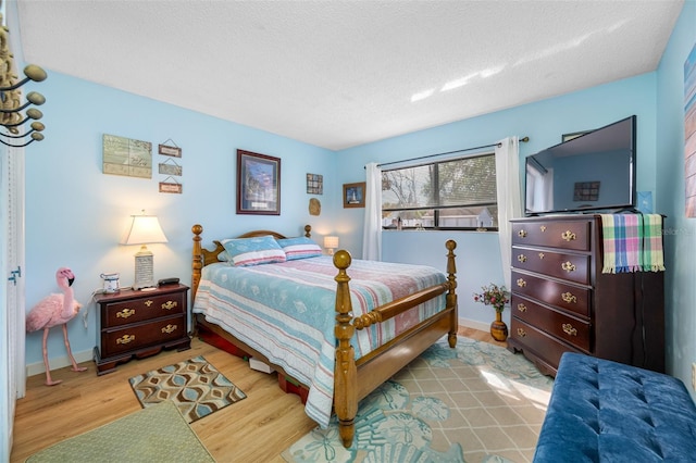 bedroom with a textured ceiling and light wood-type flooring