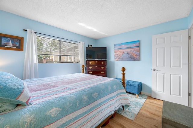 bedroom featuring light hardwood / wood-style flooring and a textured ceiling