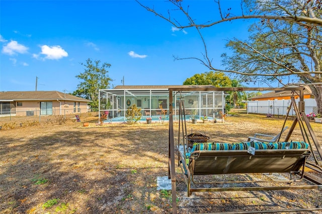 back of property with a fenced in pool and glass enclosure