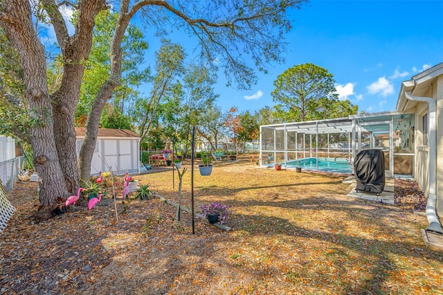 view of yard featuring a fenced in pool, a lanai, and a storage unit