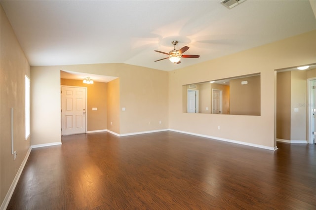 empty room with baseboards, visible vents, lofted ceiling, dark wood-style floors, and ceiling fan with notable chandelier