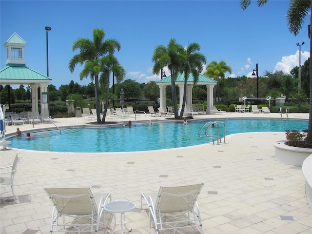 community pool with a patio area and a gazebo