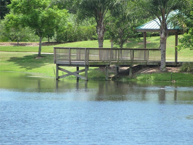 view of dock featuring a water view and a lawn