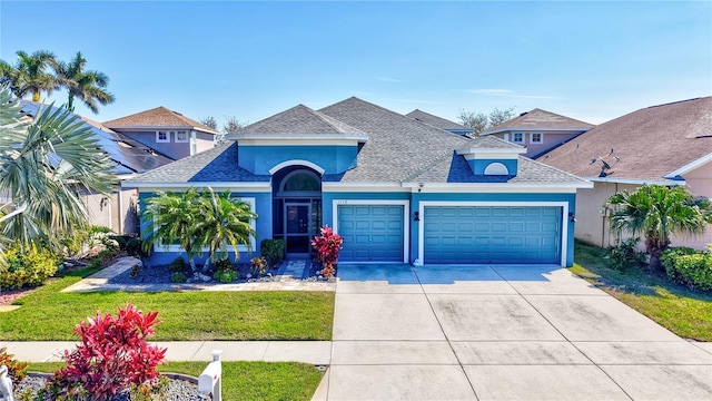 view of front of property with a shingled roof, concrete driveway, an attached garage, and stucco siding