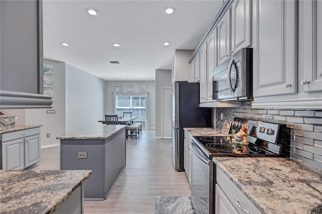 kitchen featuring appliances with stainless steel finishes, a kitchen island, and gray cabinetry