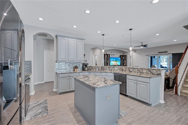 kitchen with dishwasher, light wood-type flooring, decorative backsplash, a peninsula, and refrigerator