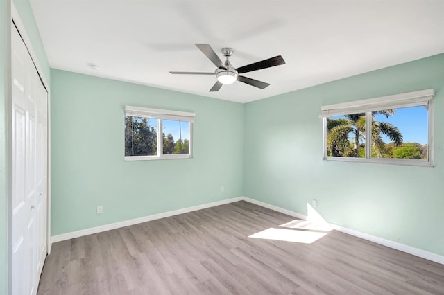 unfurnished bedroom featuring ceiling fan, light hardwood / wood-style floors, and a closet