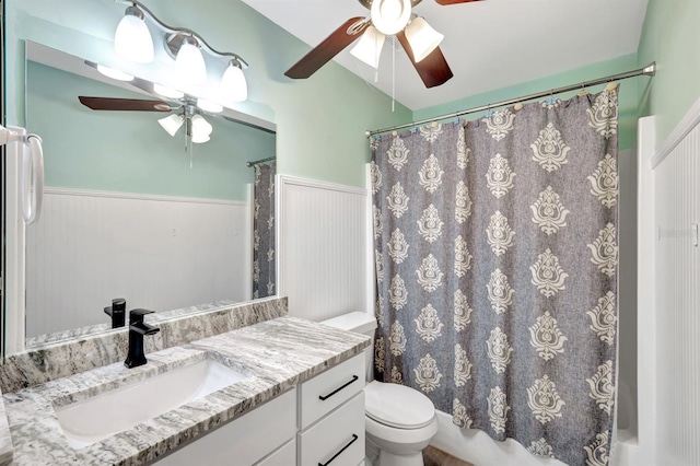 full bathroom featuring shower / bath combination with curtain, ceiling fan, vanity, and toilet