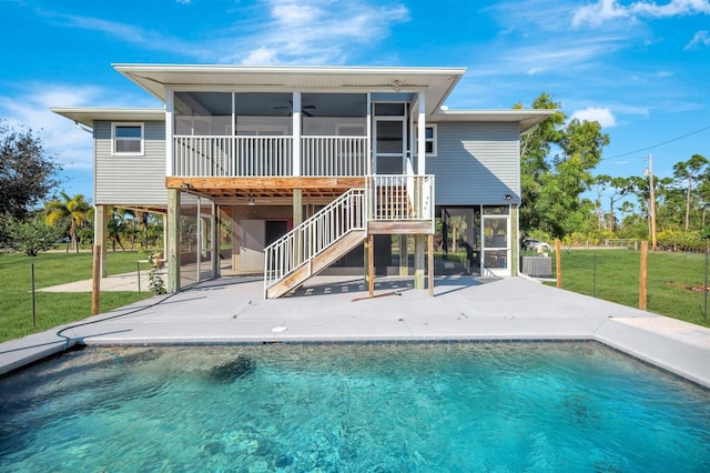 rear view of property with a yard, a sunroom, a patio, and ceiling fan