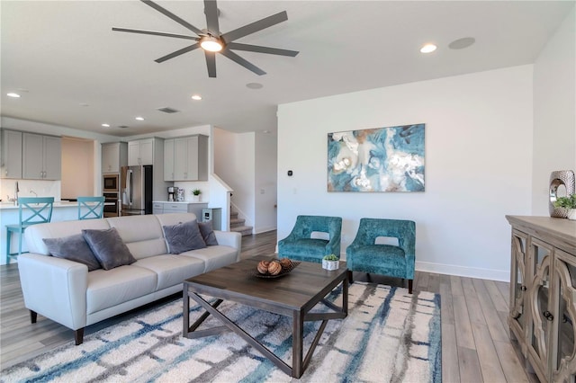 living room featuring light hardwood / wood-style floors and ceiling fan