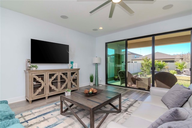 living room with light hardwood / wood-style floors and ceiling fan