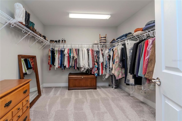 walk in closet featuring light colored carpet