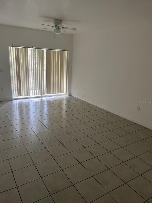 tiled spare room featuring ceiling fan