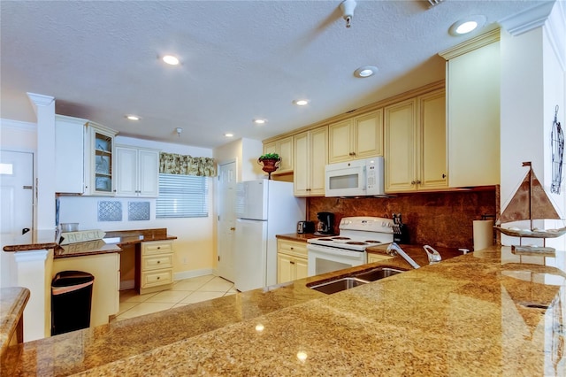 kitchen featuring sink, white appliances, light tile patterned floors, tasteful backsplash, and cream cabinets