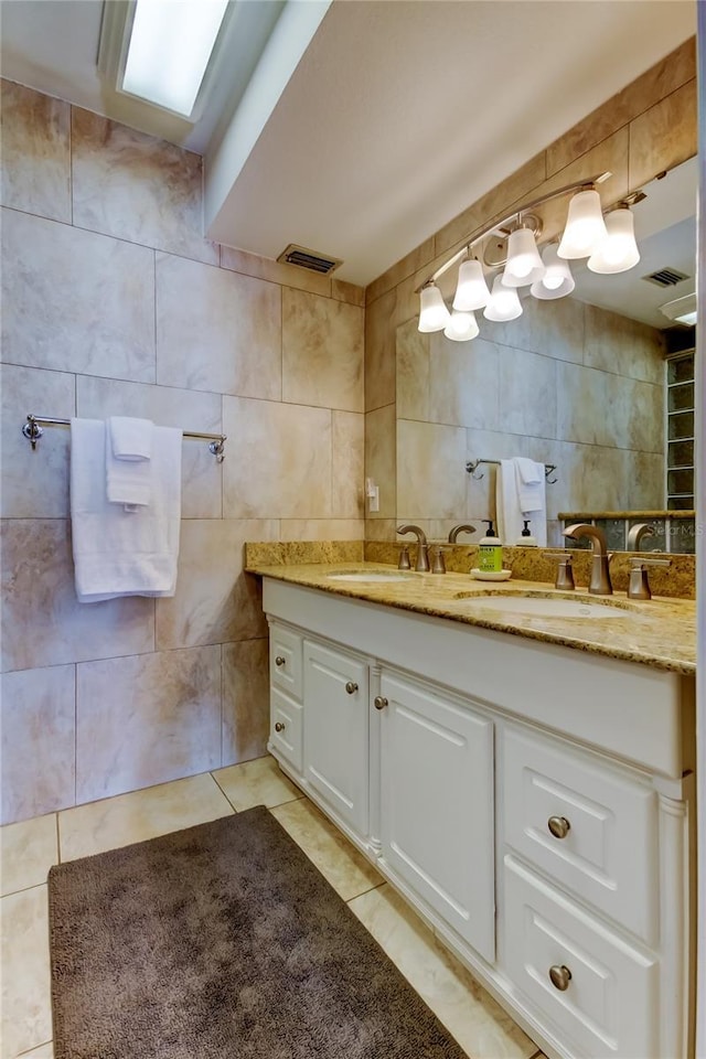 bathroom featuring vanity, tile patterned flooring, and tile walls