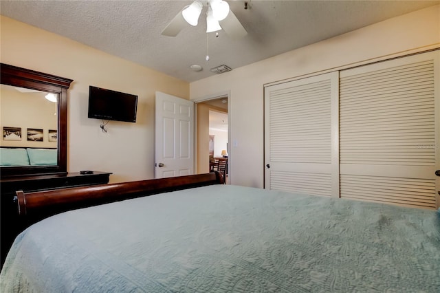 bedroom with a textured ceiling, ceiling fan, and a closet