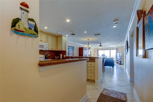 kitchen with range, decorative light fixtures, light tile patterned floors, kitchen peninsula, and cream cabinetry