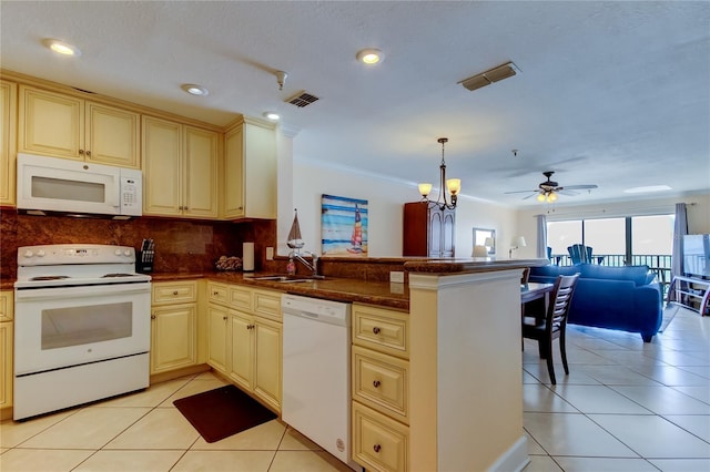 kitchen with decorative light fixtures, sink, white appliances, and kitchen peninsula