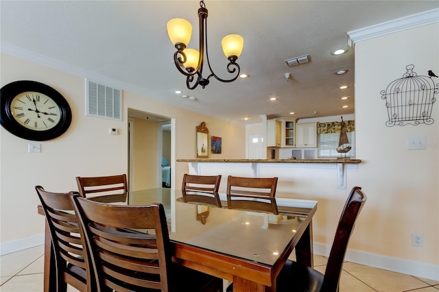 tiled dining area featuring an inviting chandelier and ornamental molding