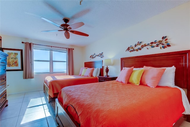 tiled bedroom featuring a textured ceiling and ceiling fan