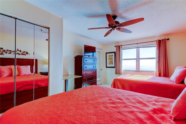 bedroom with ceiling fan and a textured ceiling