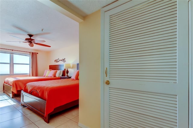 bedroom featuring ceiling fan, a textured ceiling, and light tile patterned floors