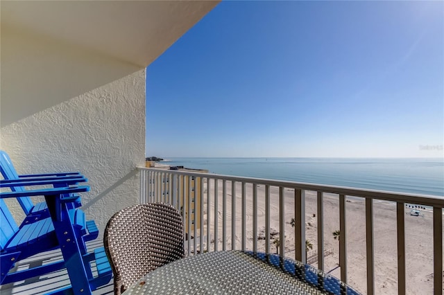 balcony featuring a water view and a beach view