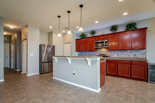 kitchen with stainless steel appliances, light stone countertops, a kitchen island, and a breakfast bar area