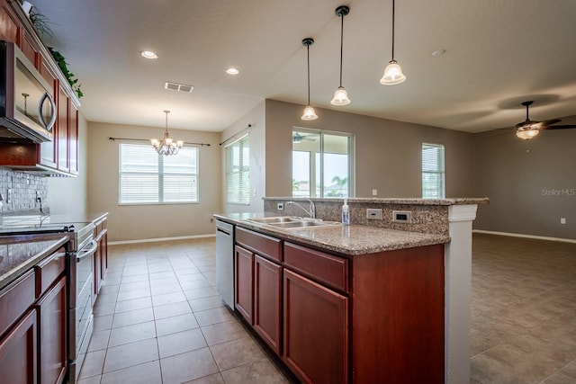 kitchen with pendant lighting, an island with sink, sink, backsplash, and stainless steel appliances