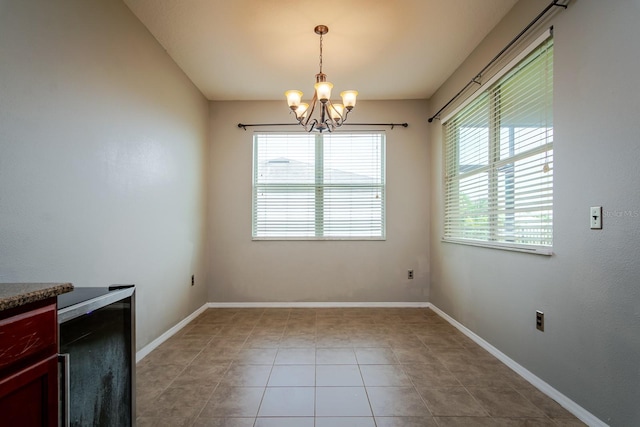 unfurnished dining area featuring an inviting chandelier and light tile patterned floors