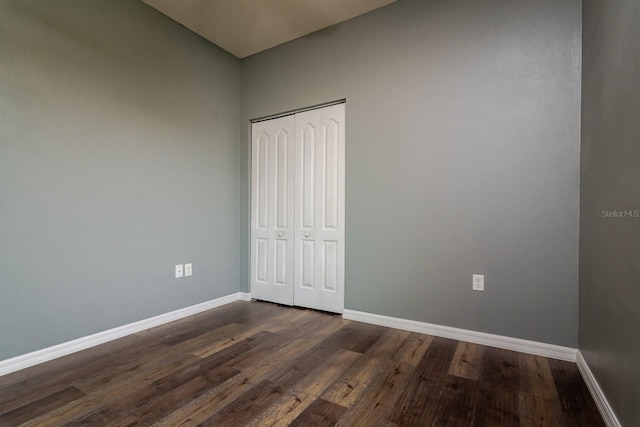 unfurnished bedroom featuring dark hardwood / wood-style floors and a closet