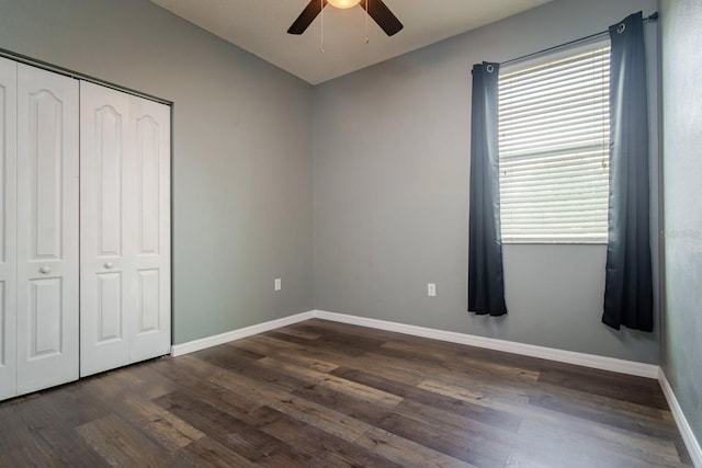 unfurnished bedroom with ceiling fan, dark hardwood / wood-style flooring, and a closet