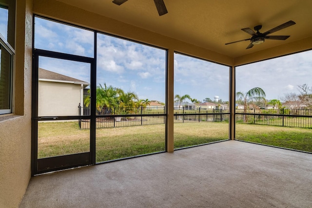 unfurnished sunroom featuring a wealth of natural light and ceiling fan