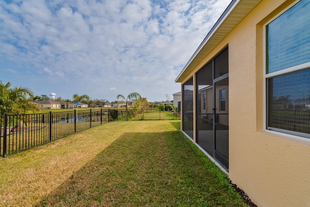 view of yard featuring a water view and a sunroom