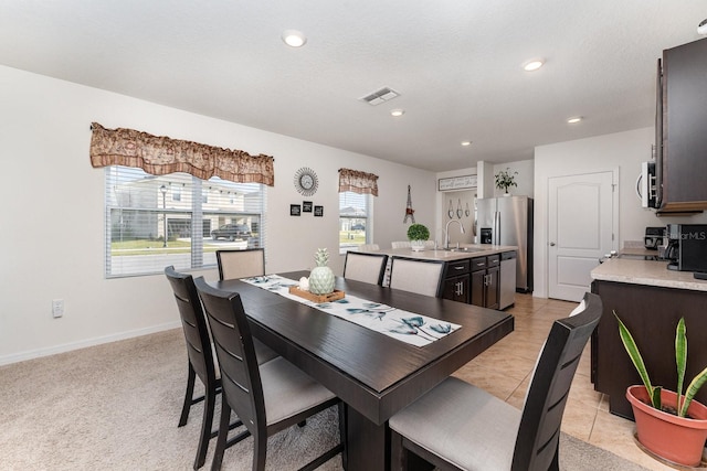 tiled dining room featuring sink and a textured ceiling