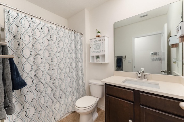 bathroom with tile patterned flooring, vanity, and toilet