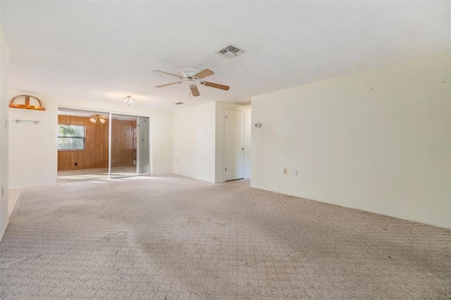 spare room featuring ceiling fan, light colored carpet, and a textured ceiling