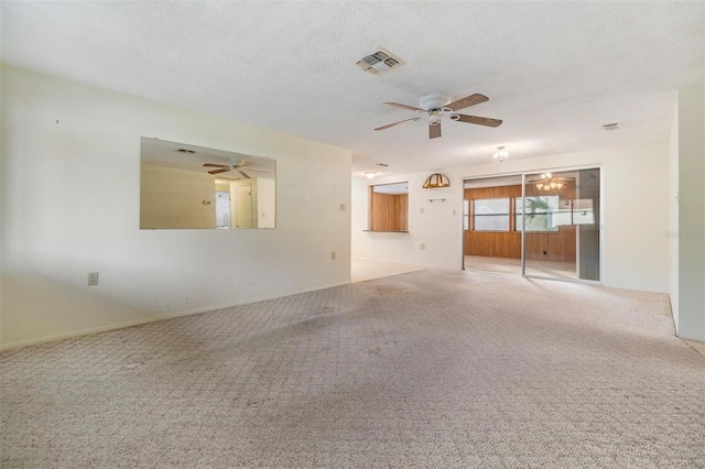 empty room with ceiling fan, light colored carpet, and a textured ceiling