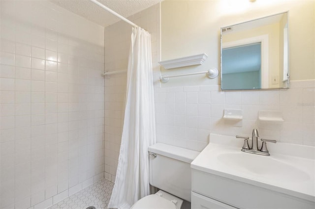 bathroom with toilet, tile walls, a textured ceiling, vanity, and curtained shower