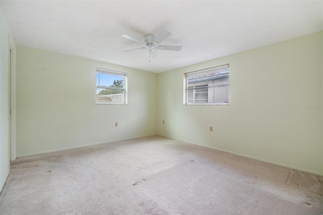 carpeted spare room featuring ceiling fan