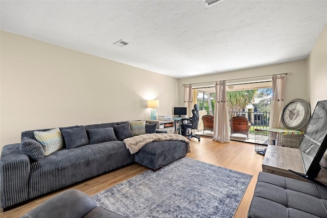 living room featuring french doors, hardwood / wood-style floors, and a textured ceiling