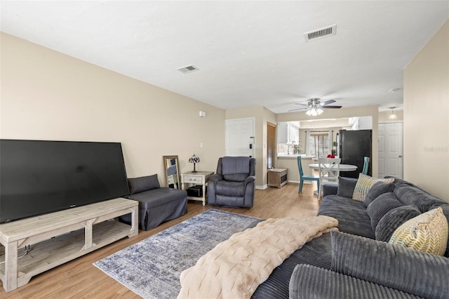 living room featuring ceiling fan and light hardwood / wood-style flooring