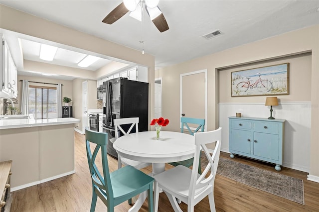 dining room featuring sink, light hardwood / wood-style flooring, and ceiling fan