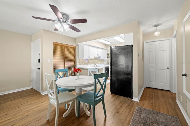 dining space featuring sink and light hardwood / wood-style flooring