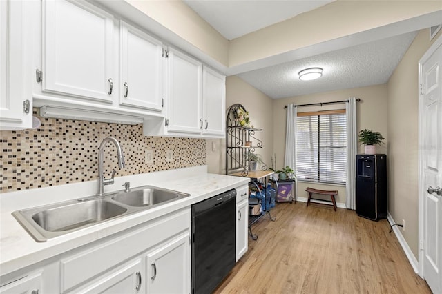 kitchen featuring black dishwasher, sink, a textured ceiling, and white cabinets