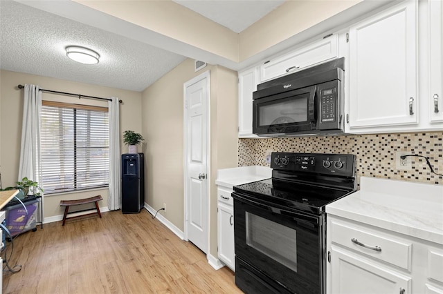 kitchen with tasteful backsplash, white cabinetry, black appliances, a textured ceiling, and light hardwood / wood-style flooring